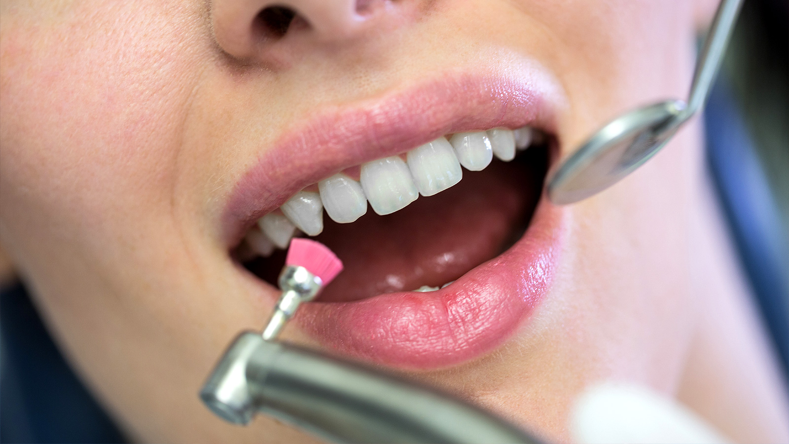 Стоматолог осматривает пациентку с помощью инструментов