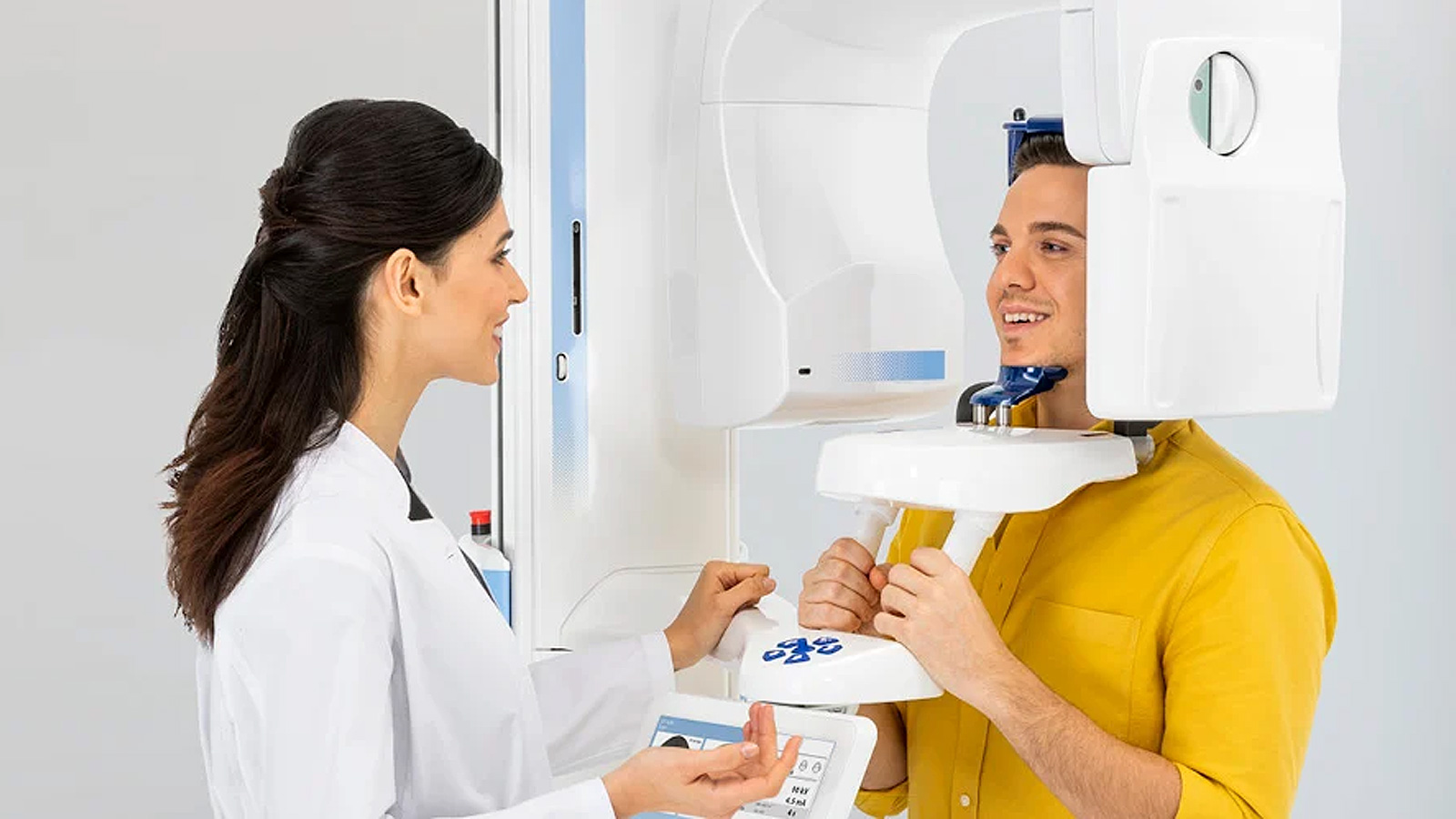 Пациент, проходящий обследование на стоматологическом рентгеновском аппарате Planmeca ProMax® 3D Classic под наблюдением медицинского работника.