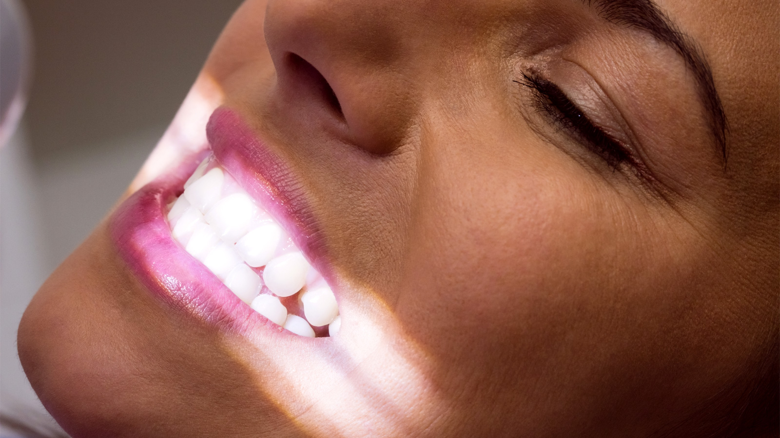 женщина-пациентка демонстрирует здоровую улыбку